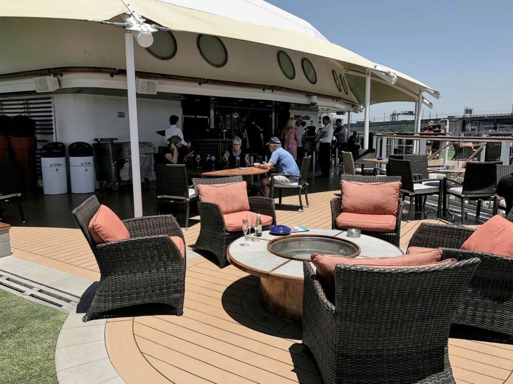 an outdoor bar with seating at the back of a ship