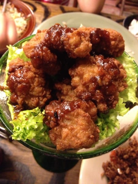 salt and pepper squid food on a bed of iceburg lettuce in a glass dish